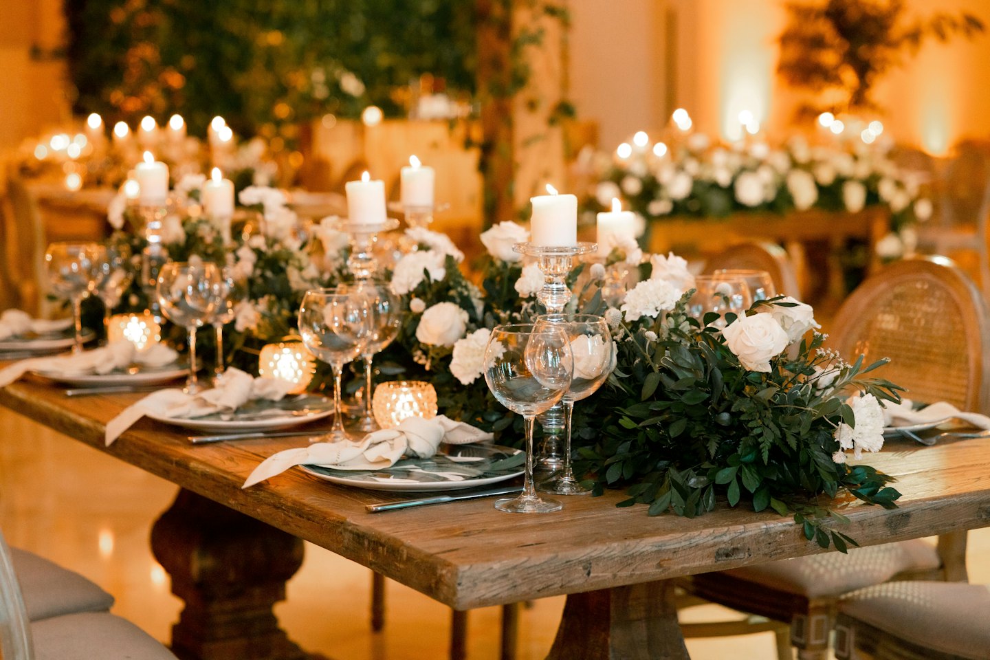 Elegante tavolo da evento con fiori, candele e segnaposto.