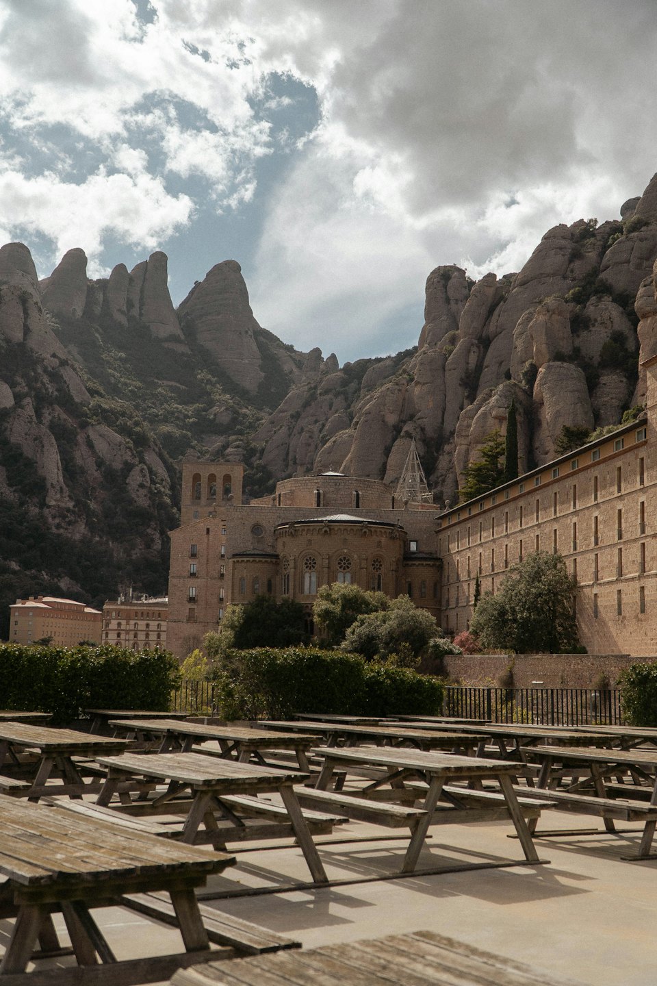 Tavoli da picnic vuoti su un patio davanti a un monastero di montagna.